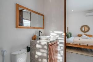 un bagno con lavandino, specchio e letto di CASA BIARI : Tropical Vibes - 3 min from beach a Canggu Altre 37 foto
