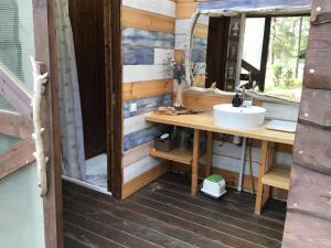 a bathroom with a sink and a mirror at Treehouse Čiekurs in Duķuri