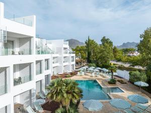 eine Luftansicht eines Hotels mit Pool und Sonnenschirmen in der Unterkunft Cabot Las Velas Apartments in Port de Pollença