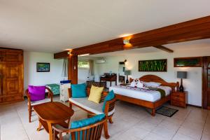 una camera da letto con un letto, un tavolo e delle sedie di Chalets Cote Mer a Baie Sainte Anne