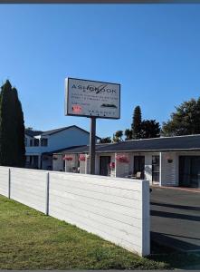 a sign in front of a white fence at Ashbrook Motel Taupo in Taupo