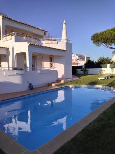 a villa with a swimming pool in front of a house at Nightingale Villa in Albufeira