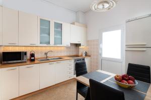 a kitchen with white cabinets and a table with a bowl of fruit at Olea Villa in Archipolis