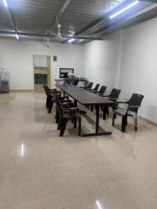 斋浦尔JSR Boys Hostel - Pratap Nagar的一间会议室,配有大桌子和椅子