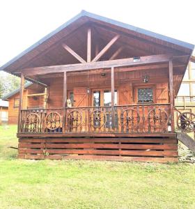 a wooden cabin with a balcony and a dog on it at l'écureuil in Saint-Laurent-en-Grandvaux