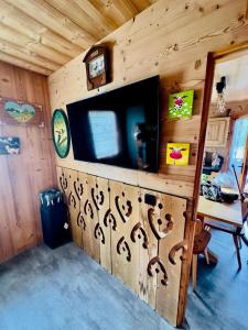 una sala de estar con TV en una cabaña en l'écureuil, en Saint-Laurent-en-Grandvaux