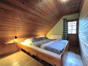 a bed in a wooden room with a wooden ceiling at Ulmenhof Melfsen in Oeversee