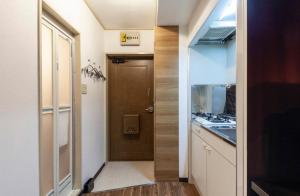 a small kitchen with a door and a sink at SunPalace Nishi-Shinjuku in Tokyo