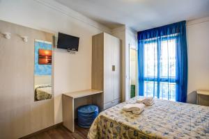 a bedroom with a bed and a tv and a window at Hotel Letizia in Bellaria-Igea Marina