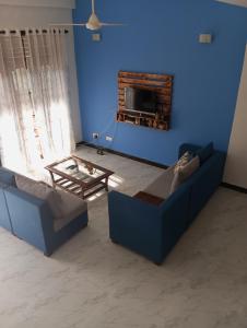 a blue living room with a couch and a table at Anne's Homestay in Gampaha
