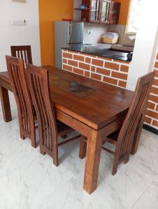 a wooden table and chairs in a kitchen at Anne's Homestay in Gampaha