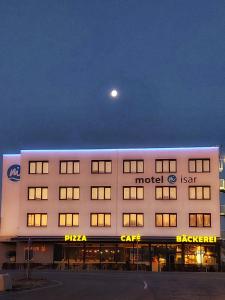 un edificio de hotel con una luna en el cielo en motel isar | 24h/7 checkin en Pilsting