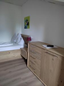 - une chambre avec un lit et une armoire en bois dans l'établissement Garni Brunnenhof, à Caldaro