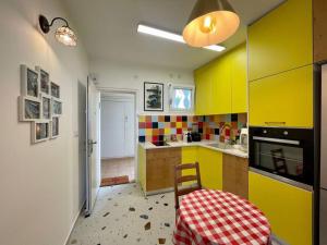 uma cozinha com armários amarelos e coloridos e uma mesa em נוף לים 3 חדרים בנאות גולף בקסריה עם בריכה וחדר כושר em Caesarea