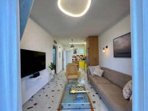 uma sala de estar com um sofá e uma televisão em נוף לים 3 חדרים בנאות גולף בקסריה עם בריכה וחדר כושר em Caesarea