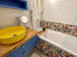 uma casa de banho com um lavatório amarelo e uma banheira em נוף לים 3 חדרים בנאות גולף בקסריה עם בריכה וחדר כושר em Caesarea