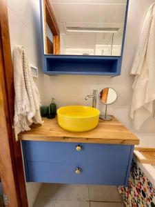 a bathroom with a yellow sink and a blue cabinet at נוף לים 3 חדרים בנאות גולף בקסריה עם בריכה וחדר כושר in Caesarea