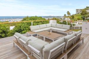 a patio with a couch and a table on a deck at Ocean View w/ Huge Balcony @ Las Gaviotas Fajardo - Las Gaviotas A29 - Nuevo in Ceiba