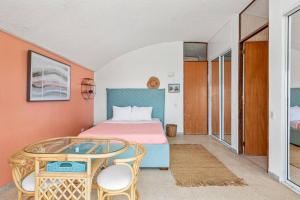 a bedroom with a bed and a table and chairs at Ocean View w/ Huge Balcony @ Las Gaviotas Fajardo - Las Gaviotas A29 - Nuevo in Ceiba