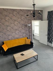 a living room with a couch and a table at Stylish 91sqm Victoria 2 bedroom Apartment in Bristol