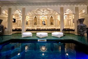 a swimming pool with two white pillows in a building at Riad Citrus in Marrakech