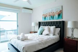 聖胡安的住宿－Spacious Comfy PH Apt for 9 @ San Juan - Miramar 4 - Nuevo，卧室配有一张带白色床单和枕头的大床。
