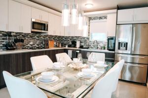 a kitchen with a glass table and white chairs at Spacious Comfy PH Apt for 9 @ San Juan - Miramar 4 - Nuevo in San Juan