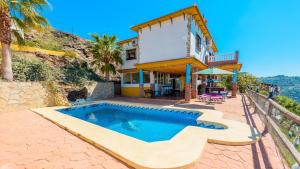 a villa with a swimming pool in front of a house at Cortijo La Encina Sayalonga by Ruralidays in Sayalonga