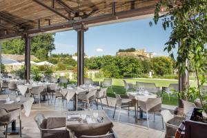 een restaurant met tafels en stoelen op een patio bij La Ferme Chapouton - Teritoria in Grignan