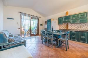 a kitchen with green cabinets and a table and chairs at Casa Vacanze L'olivo in Olìa Speciosa