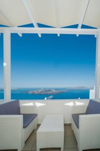 a room with chairs and a view of the ocean at Corrado Caldera Apartments in Fira