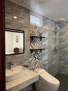 a bathroom with a toilet and a sink and a mirror at Villa Namkhan Heritage in Luang Prabang