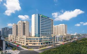 Holiday Inn Express Mianyang Sci-Tech City, an IHG Hotel في ميانيانغ: أفق المدينة مع المباني الطويلة والشارع