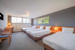 a hotel room with three beds and a window at Fletcher Hotel-Restaurant Waalwijk in Waalwijk