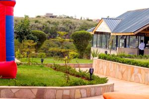 a house with a garden in front of a building at Olive Hotel Narok in Narok