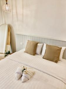 uma grande cama branca com duas almofadas em The O room em Ko Larn