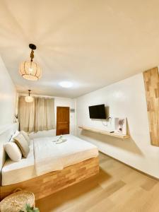 um quarto com uma cama e uma televisão na parede em The O room em Ko Larn