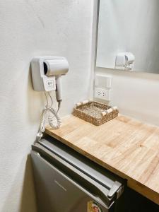 un dispensador de jabón en una pared junto a un espejo en The O room en Ko Larn