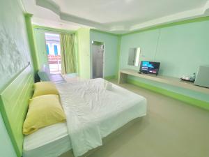 a bedroom with a white bed with yellow pillows at The O room in Ko Larn