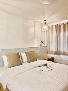 um quarto com 2 camas e lençóis brancos em The O room em Ko Larn