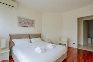 a bedroom with a white bed with two white shoes on it at Yourbanflat Monte Rosso in Teolo