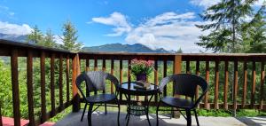 un patio con 2 sillas y una mesa en una valla en Alpine Meadows Lodge, en Golden
