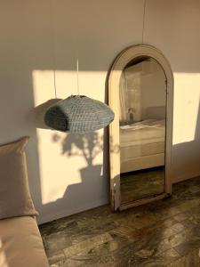 a mirror in a room with a bed and a lamp at Sea view nordic design apartment near beach great for couples in Snekkersten