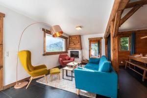 a living room with a blue couch and chairs at Le Relief - Maison avec magnifique vue montagne aux Bettex in Saint-Gervais-les-Bains