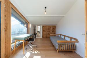 a room with a bed and a desk and a window at Le Relief - Maison avec magnifique vue montagne aux Bettex in Saint-Gervais-les-Bains
