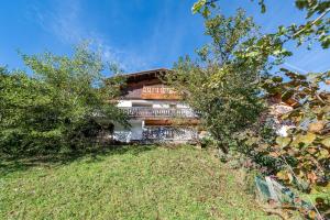 una casa sul fianco di una collina con alberi di Le Relief - Maison avec magnifique vue montagne aux Bettex a Saint-Gervais-les-Bains