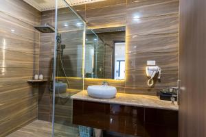 a bathroom with a sink and a glass shower at CM Hotel & Apartment in Hai Phong