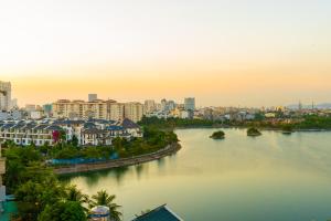 Blick auf einen Fluss in einer Stadt mit Gebäuden in der Unterkunft CM Hotel & Apartment in Haiphong