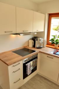 a kitchen with white cabinets and a stove top oven at Catalena in Radolfzell am Bodensee