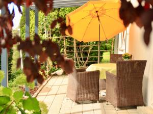 a table and chairs with an umbrella on a patio at Catalena in Radolfzell am Bodensee